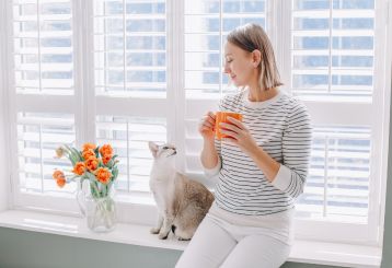 A person cleaning cordless blinds for a safe and hassle-free home environment.